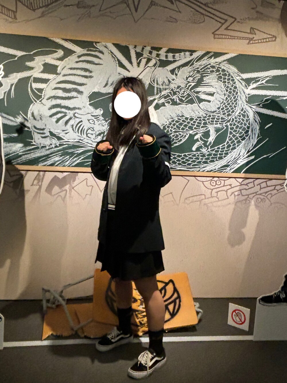 ブラック系のスカート、グレー系のパーカー、ブラック系のスニーカーを着用したレディースの秋コーディネートの2枚目の写真