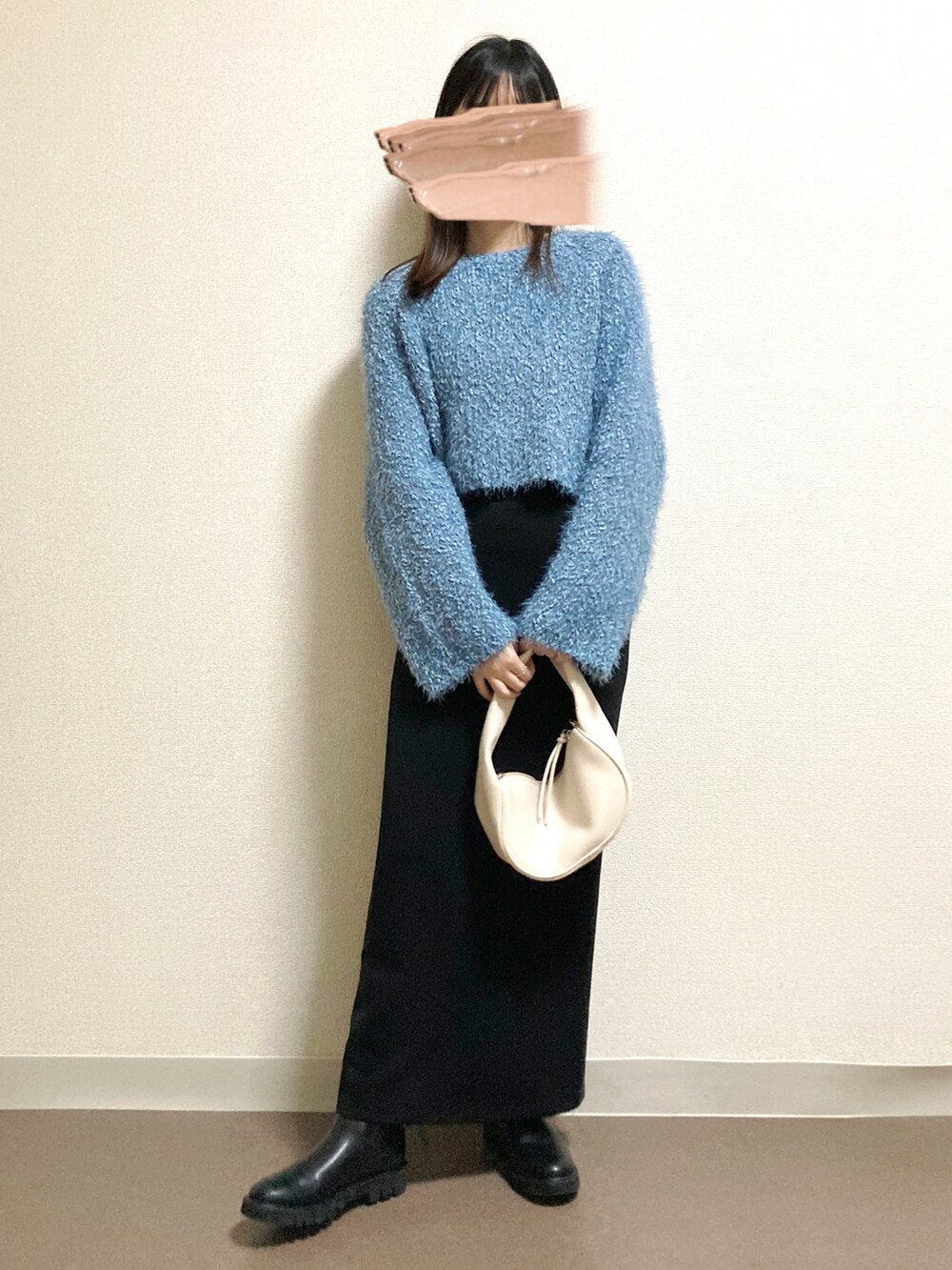 ブルー系のニット/セーター、ブラック系のスカート、ブラック系のブーツを着用したレディースの冬コーディネートの2枚目の写真