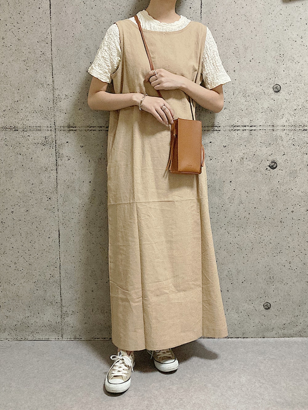 ベージュ系のスニーカー、イエロー系のショルダーバッグ、ベージュ系のワンピースを着用したレディースの夏コーディネートの2枚目の写真