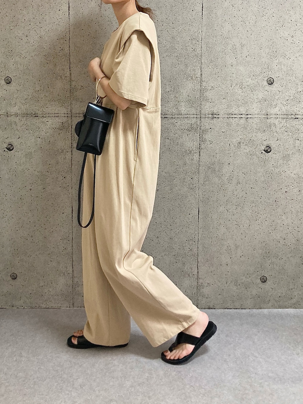ベージュ系のサロペット/オーバーオール、ブラック系のショルダーバッグ、ブラック系のサンダルを着用したレディースの夏コーディネートの2枚目の写真
