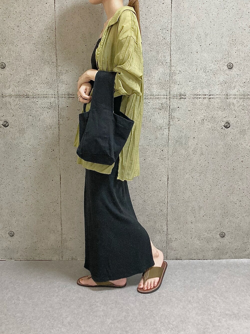 イエロー系のサンダル、ブラック系のスカート、ブラック系のタンクトップを着用したレディースの夏コーディネートの2枚目の写真