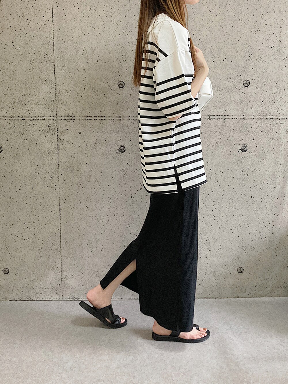 ブラック系のサンダル、ブラック系のスカート、ブラック系のTシャツ/カットソーを着用したレディースの夏コーディネートの2枚目の写真