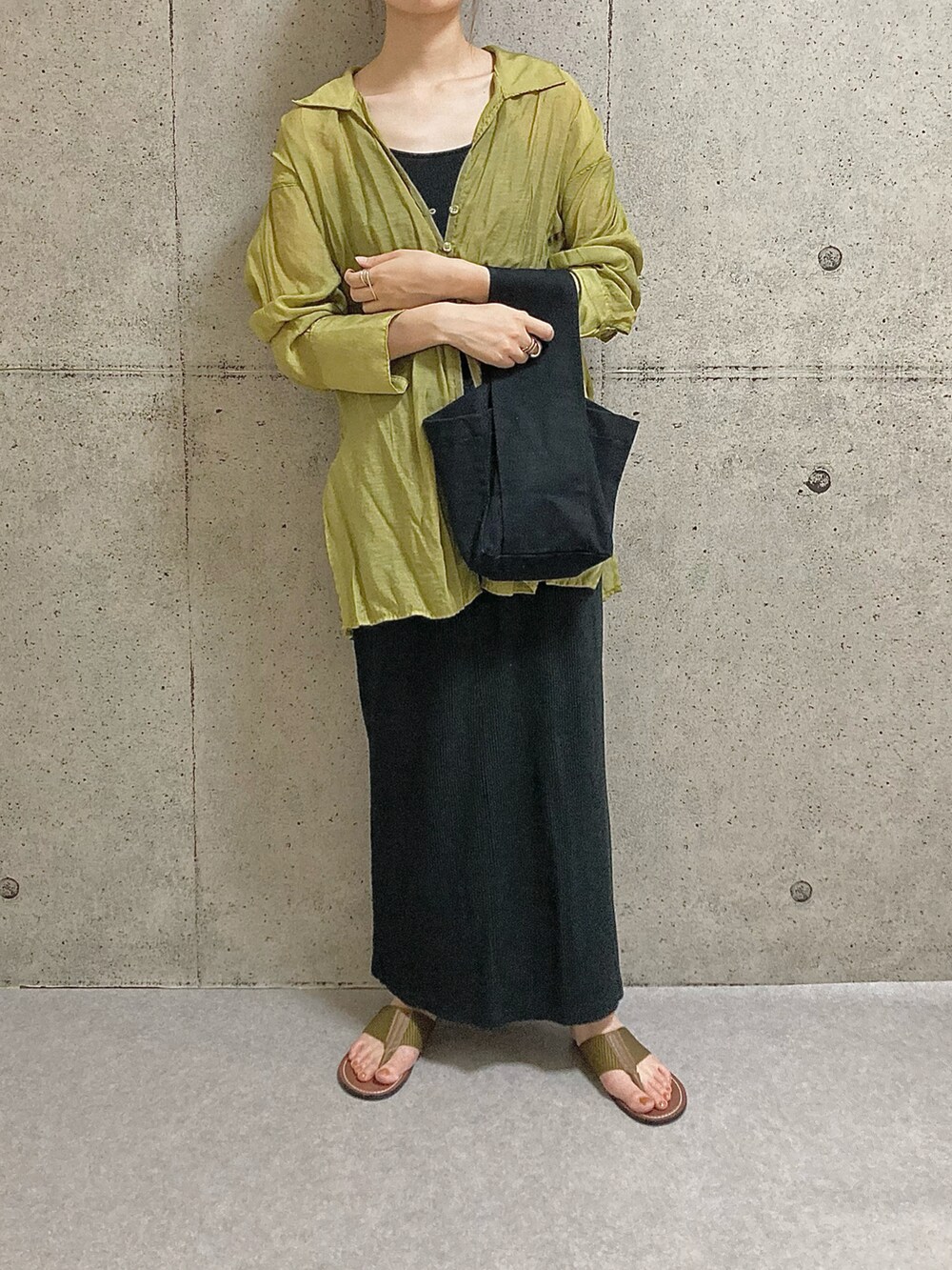 イエロー系のサンダル、ブラック系のスカート、ブラック系のタンクトップを着用したレディースの夏コーディネートの3枚目の写真