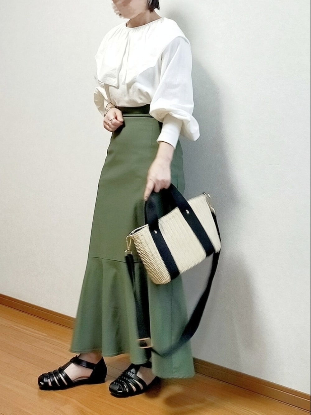 ホワイト系のTシャツ/カットソー、グリーン系のスカート、ベージュ系のかごバッグを着用したレディースの春コーディネートの2枚目の写真