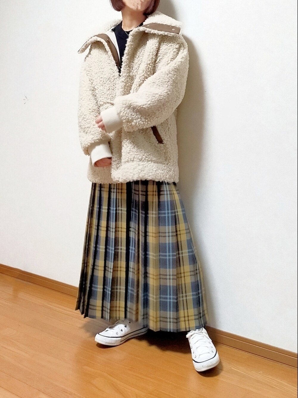 ブラック系のニット/セーター、イエロー系のスカート、ホワイト系のスニーカーを着用したレディースの冬コーディネートの2枚目の写真