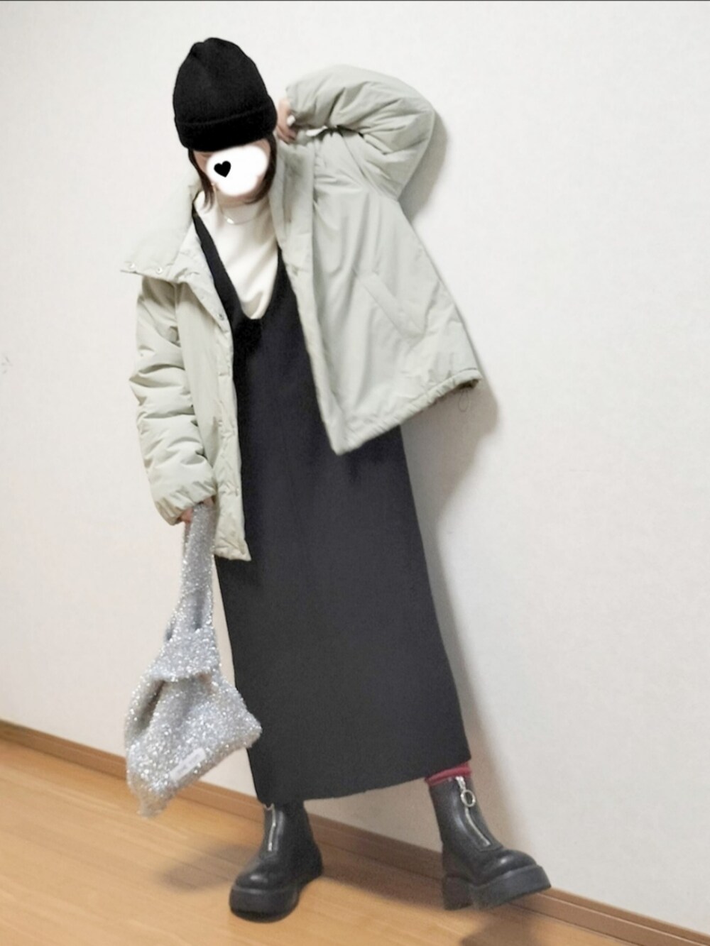 グリーン系のブルゾン、ホワイト系のスウェット、ブラック系のブーツを着用したレディースの冬コーディネートの3枚目の写真