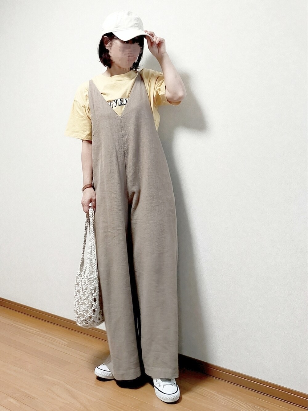 ベージュ系のサロペット/オーバーオール、イエロー系のTシャツ/カットソー、ブラック系のトートバッグを着用したレディースの夏コーディネートの2枚目の写真