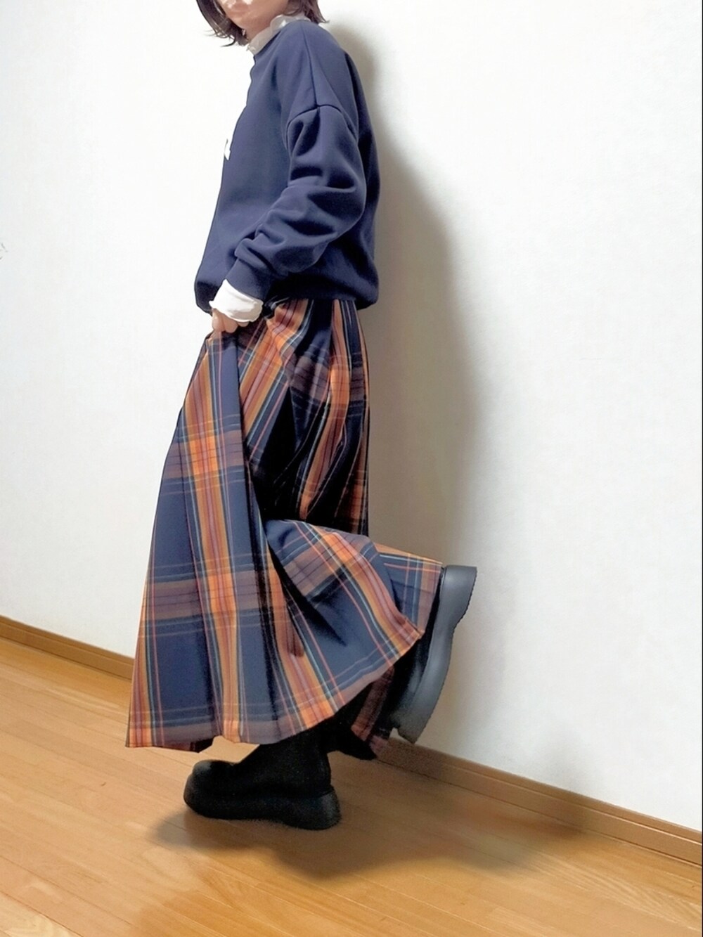 ブラック系のブーツ、ブルー系のスカート、ホワイト系のTシャツ/カットソーを着用したレディースの秋コーディネートの3枚目の写真