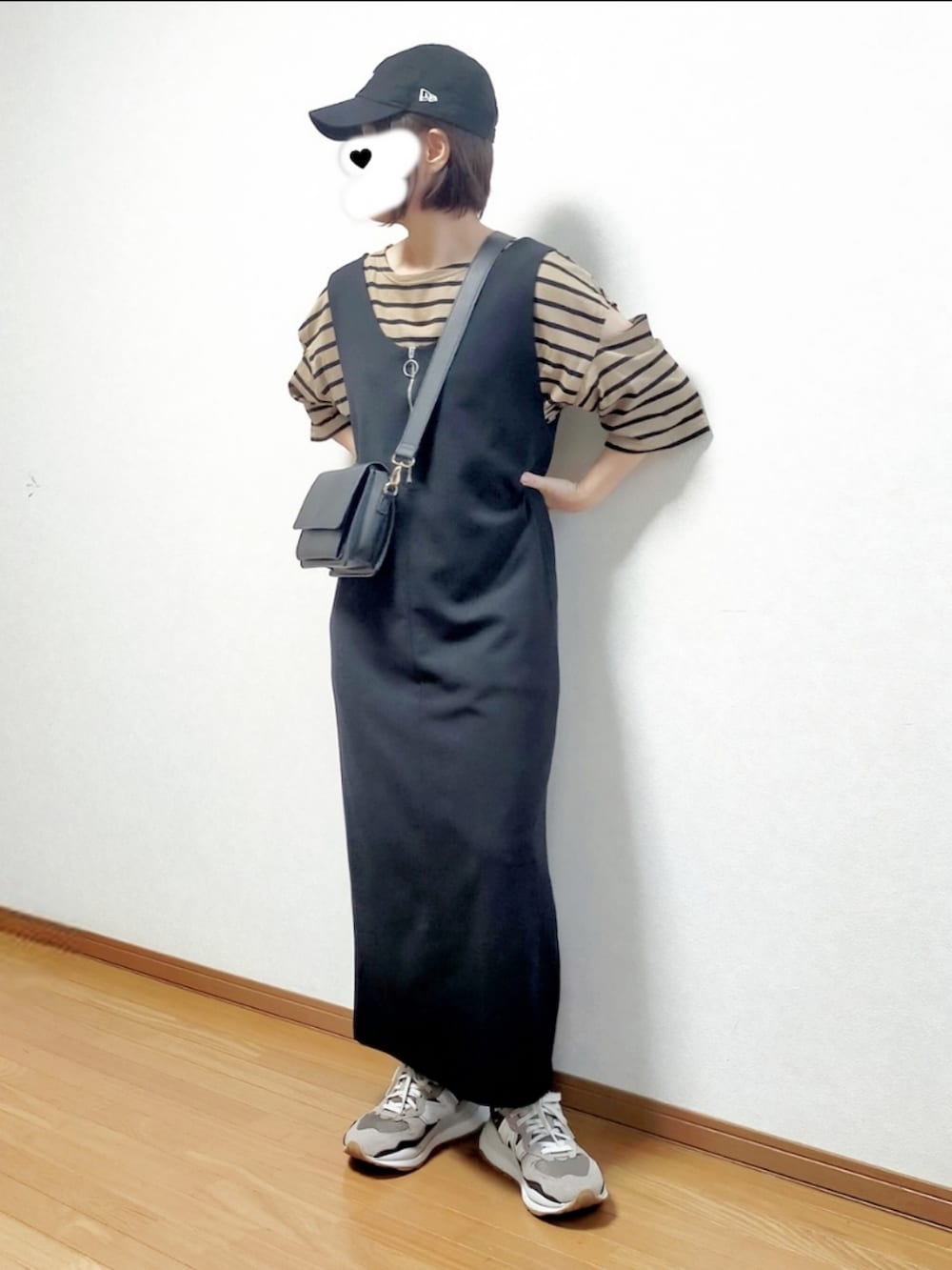 ブラウン系のTシャツ/カットソー、ブラック系のジャンパースカート、ブラック系のショルダーバッグを着用したレディースの秋コーディネートの2枚目の写真