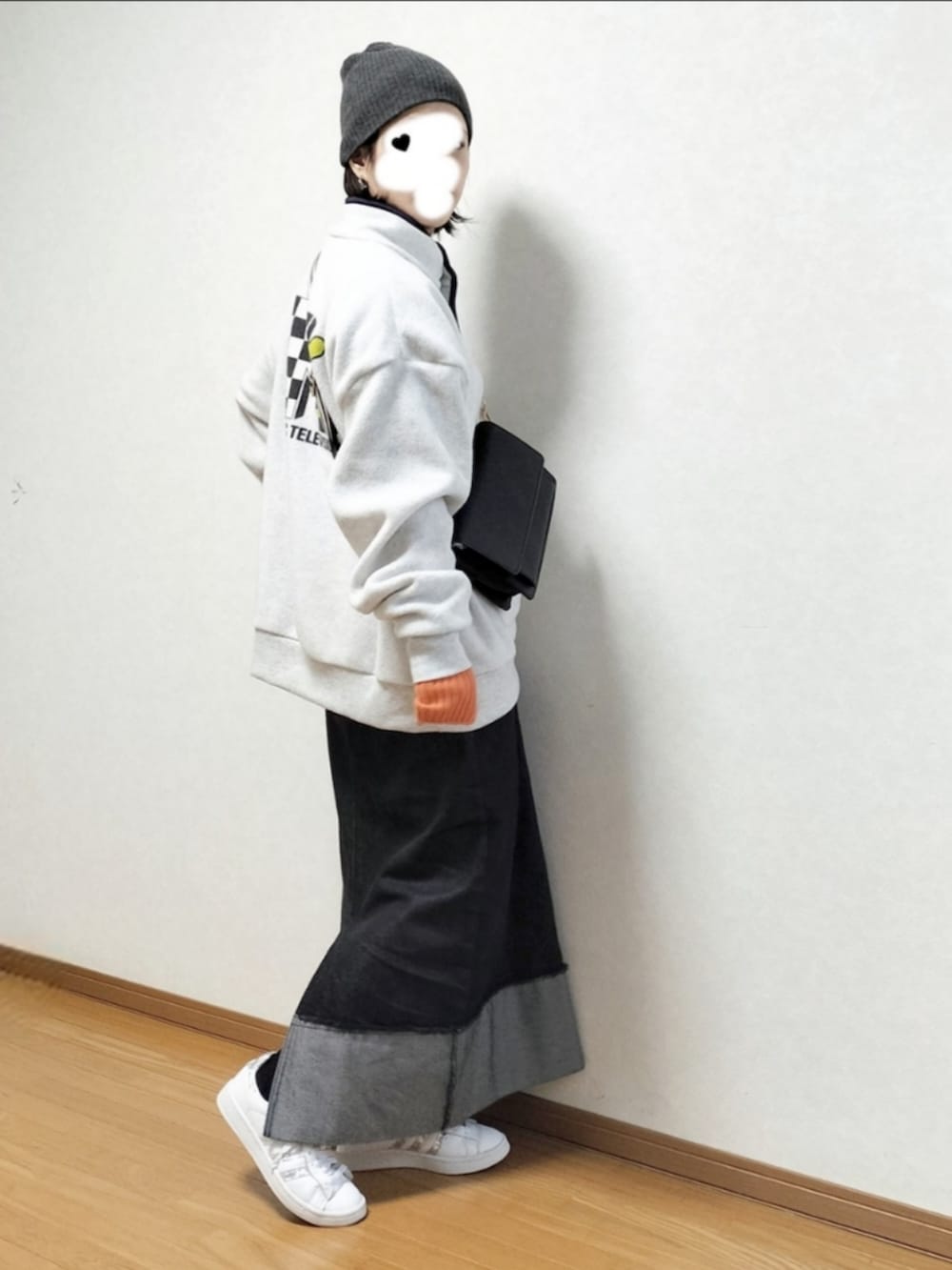 ホワイト系のスウェット、ブラック系のデニムスカート、グレー系のニットキャップ/ビーニーを着用したレディースの冬コーディネートの2枚目の写真