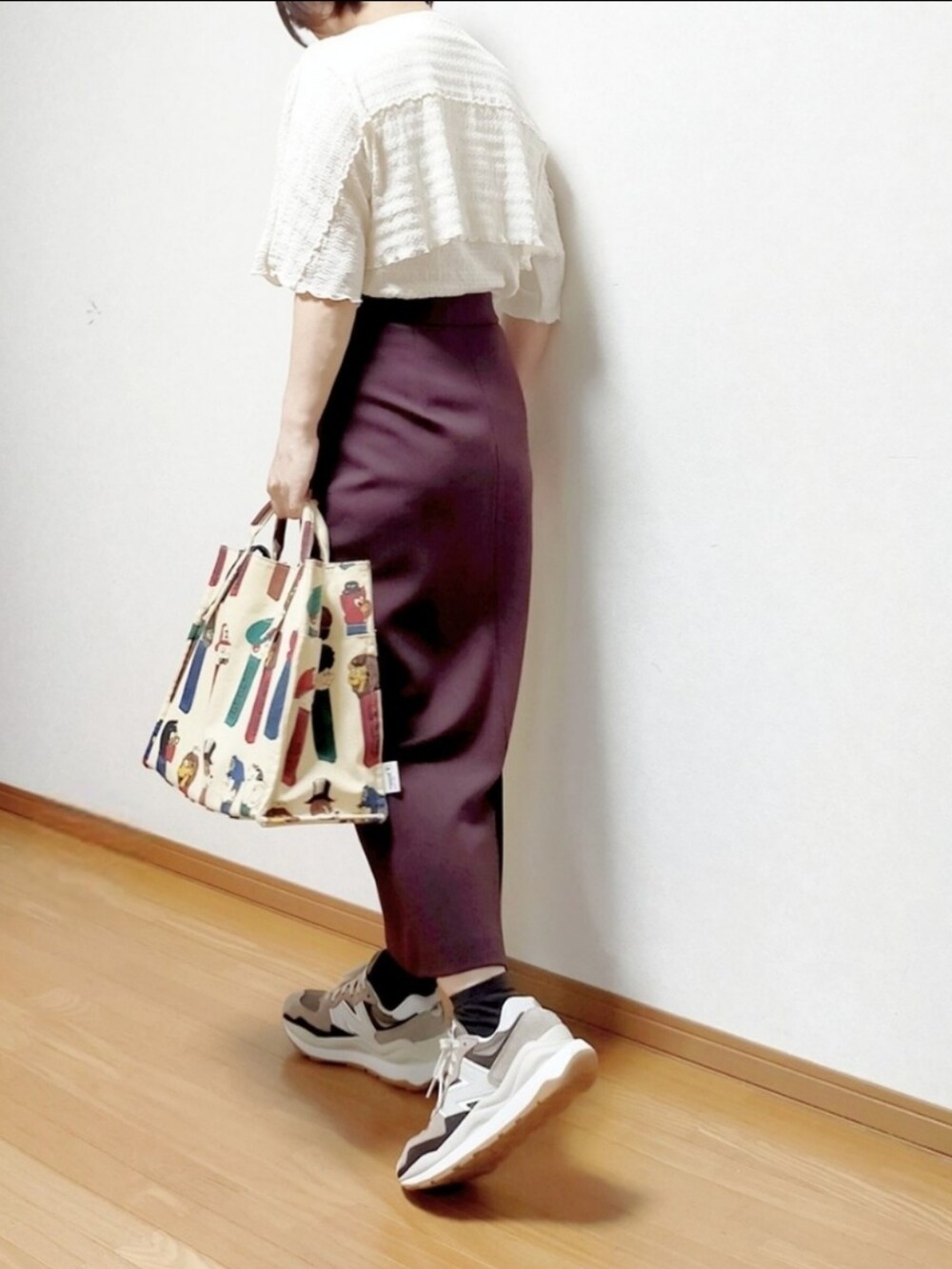ホワイト系のTシャツ/カットソー、ベージュ系のトートバッグ、ブラウン系のスニーカーを着用したレディースの秋コーディネートの2枚目の写真