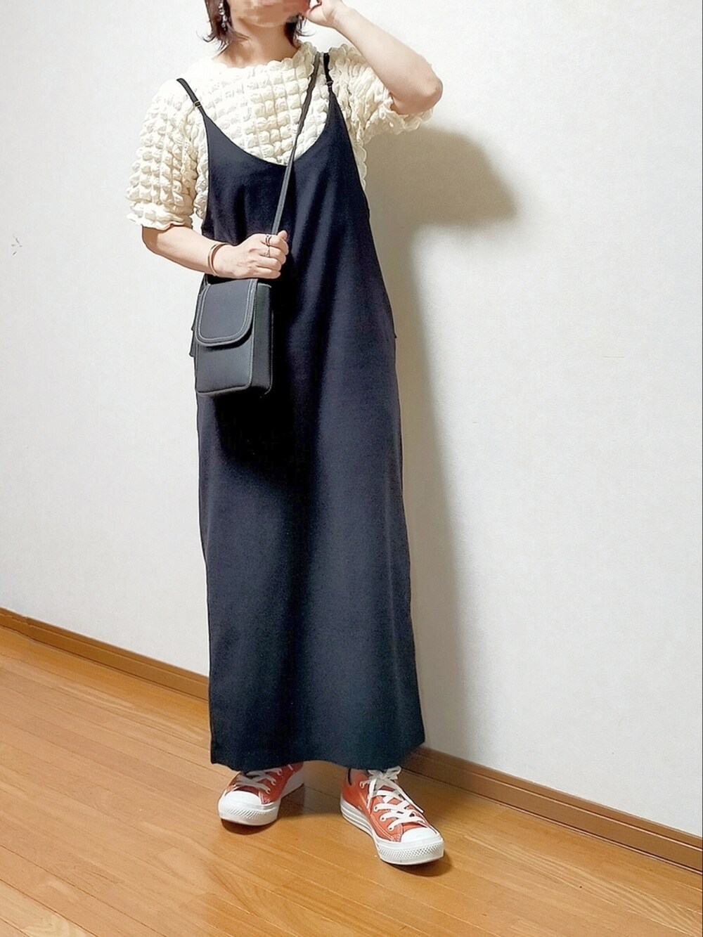 ホワイト系のシャツ/ブラウス、ブラック系のサロペット/オーバーオール、オレンジ系のスニーカーを着用したレディースの夏コーディネートの2枚目の写真