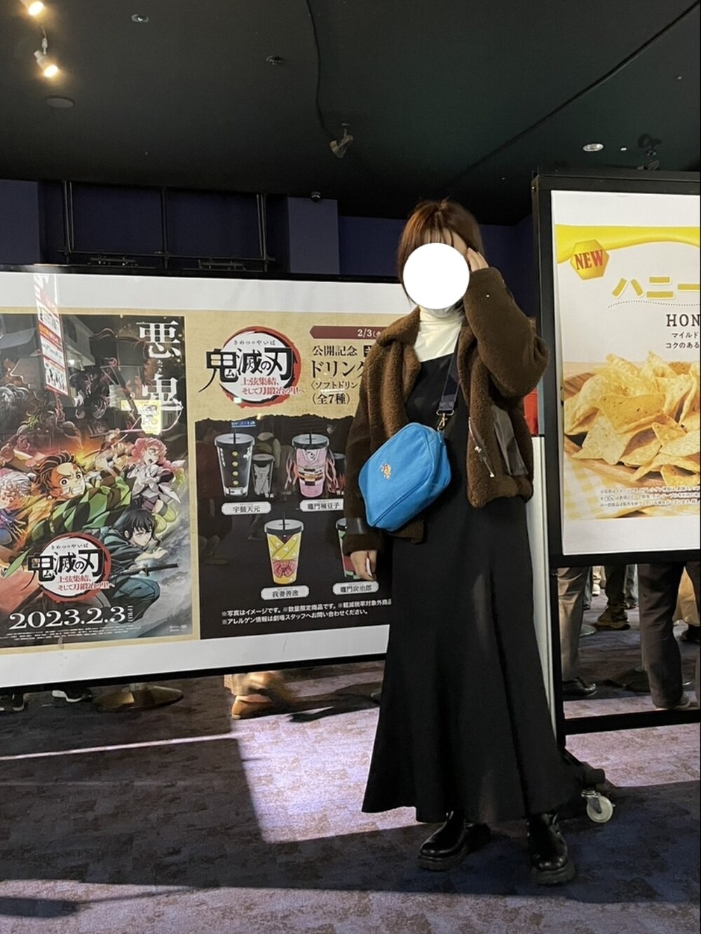 ブルー系のショルダーバッグ、ブラウン系のジャケット/アウター、ホワイト系のニット/セーターを着用したレディースの冬コーディネートの2枚目の写真