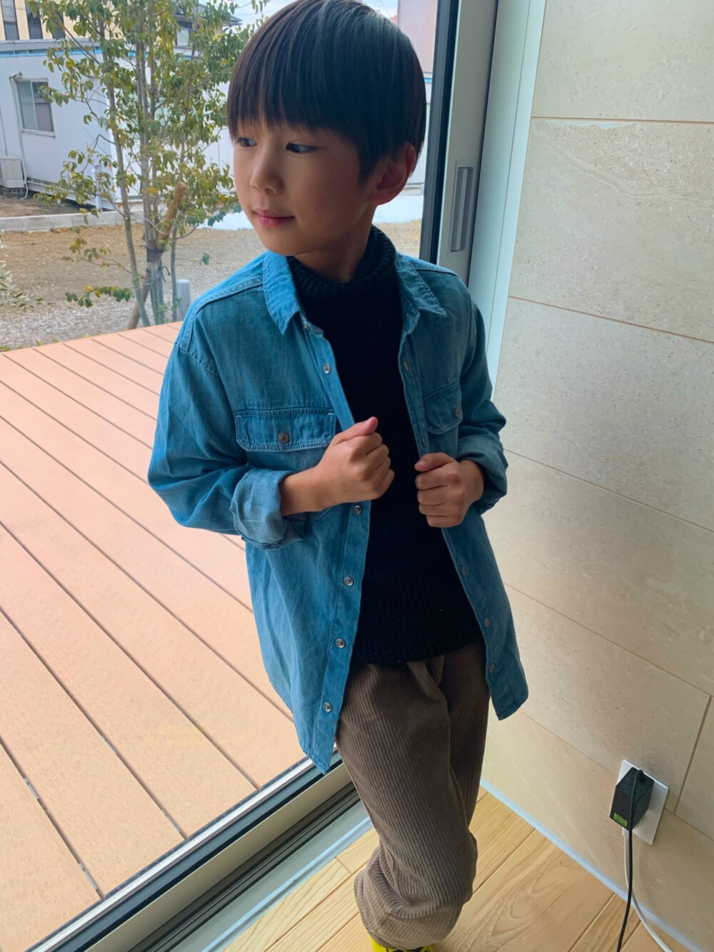 ブラック系のニット/セーター、ブルー系のデニムジャケット、ブラウン系のパンツを着用したキッズの春コーディネートの2枚目の写真