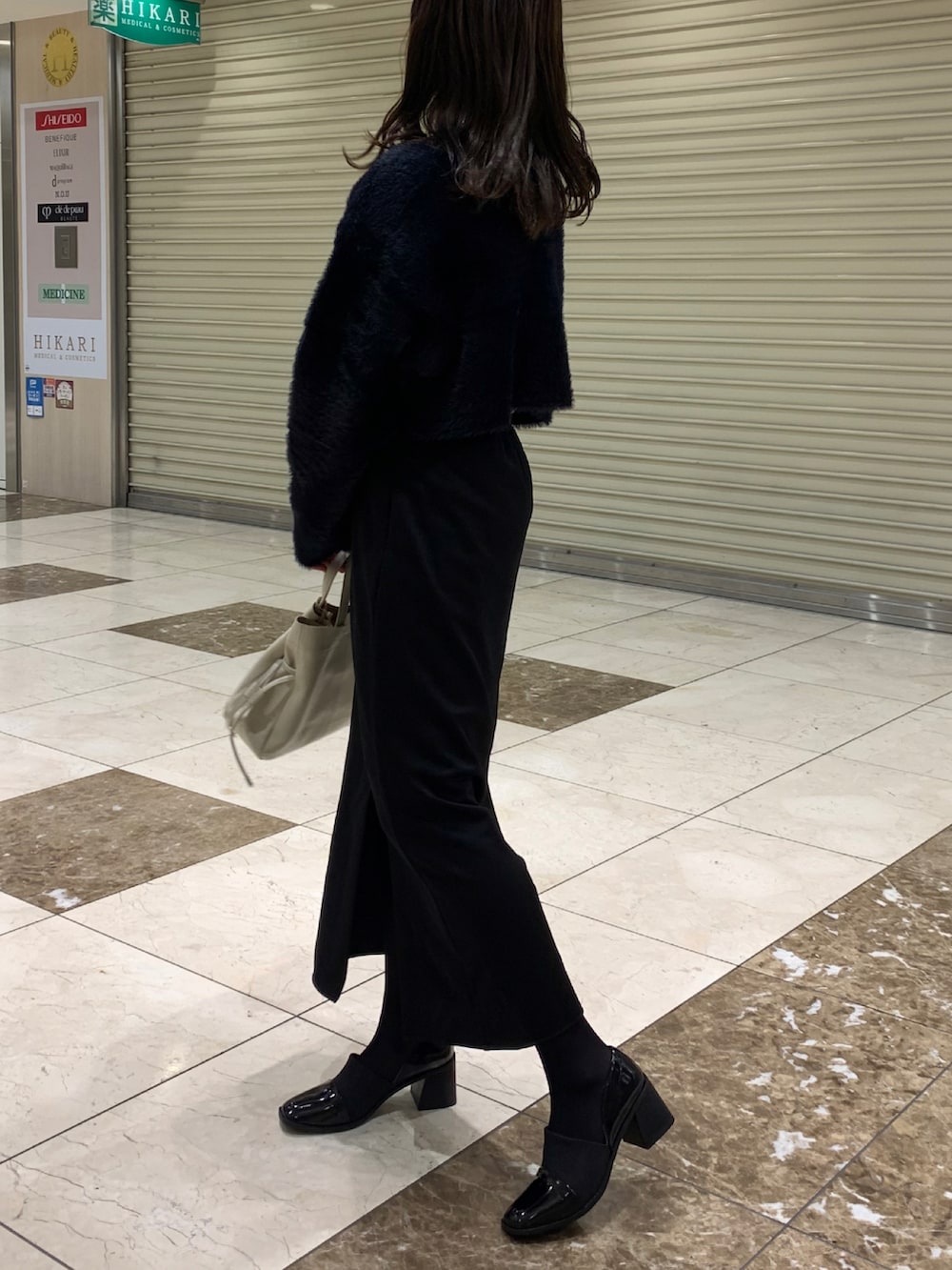 ブラック系のカーディガン/ボレロ、ブラック系のローファー、ブラック系のスカートを着用したレディースの冬コーディネートの2枚目の写真