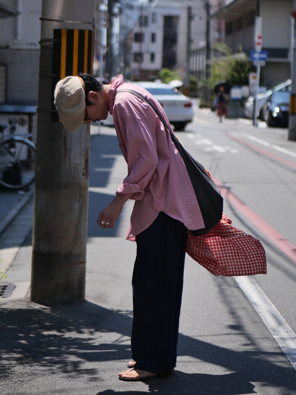 ブルー系のデニムパンツ、ブラック系のサンダル、オレンジ系のシャツ/ブラウスを着用したメンズの夏コーディネートの2枚目の写真