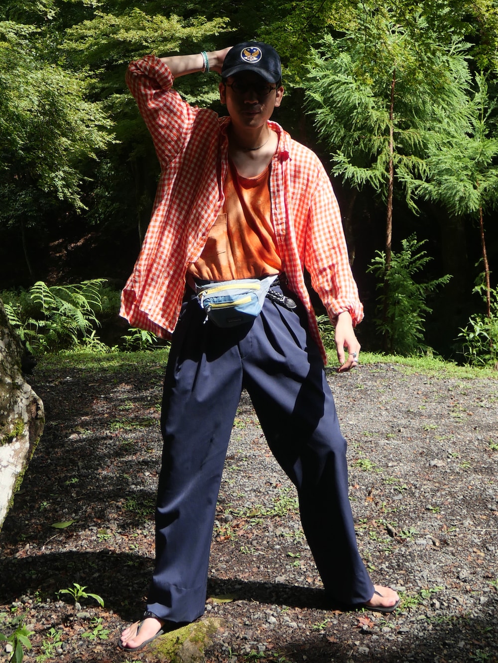 ブルー系のパンツ、ブラック系のサンダル、オレンジ系のシャツ/ブラウスを着用したメンズの夏コーディネートの2枚目の写真