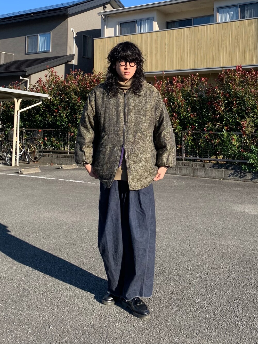 ブラック系のローファー、ブルー系のパンツ、その他のダウンジャケット/コートを着用したメンズの秋コーディネートの2枚目の写真