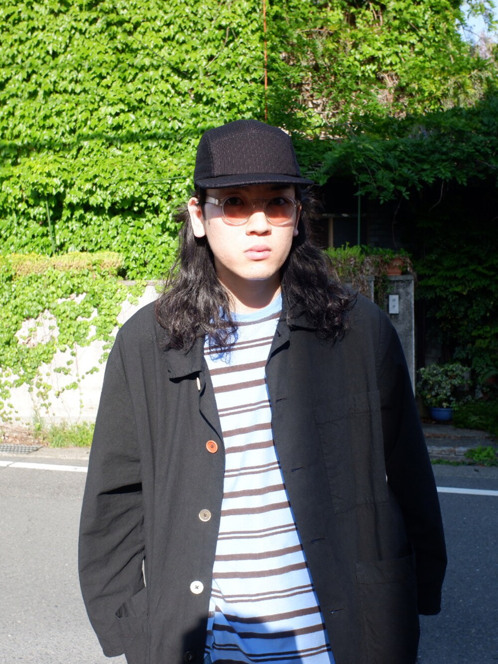 ブラック系のスニーカー、ブルー系のデニムパンツ、ブルー系のTシャツ/カットソーを着用したメンズの春コーディネートの4枚目の写真