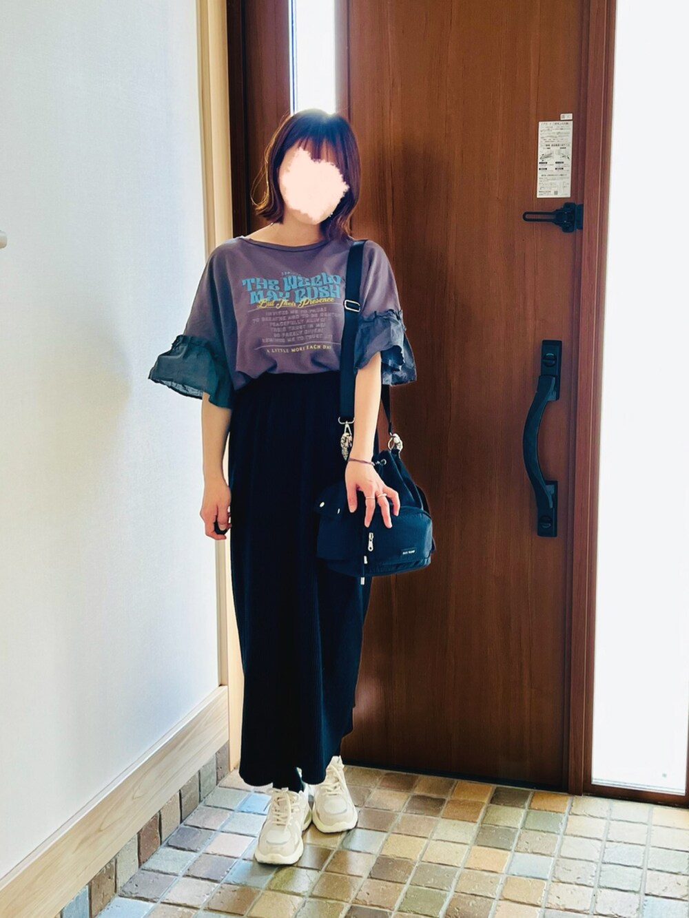 ベージュ系のスニーカー、ブラック系のTシャツ/カットソー、ブラック系のスカートを着用したレディースの春コーディネートの2枚目の写真