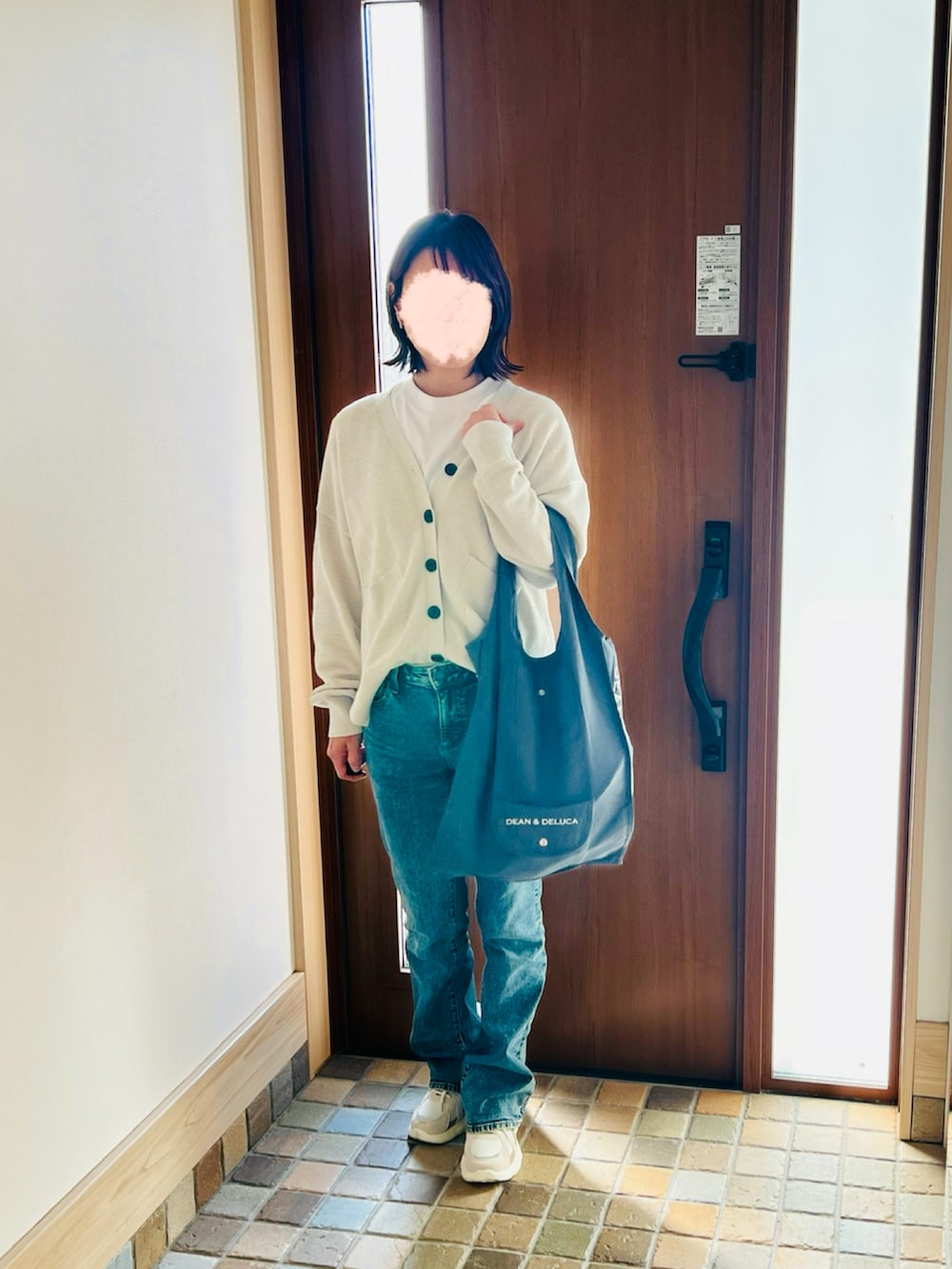 ブルー系のデニムパンツ、ベージュ系のスニーカー、ホワイト系のカーディガン/ボレロを着用したレディースの春コーディネートの2枚目の写真