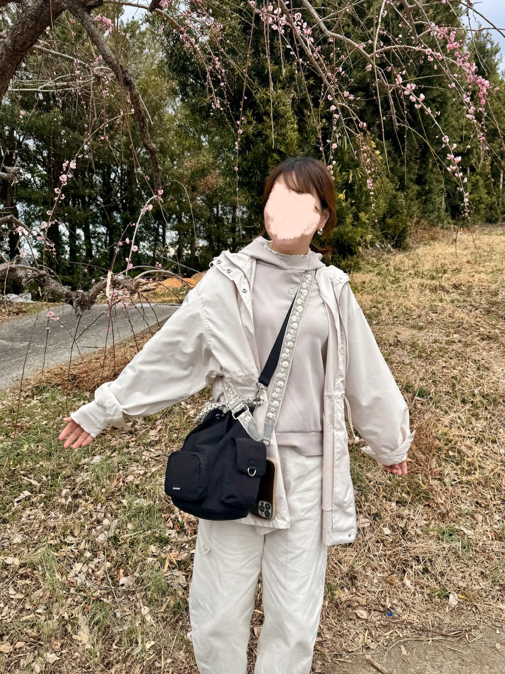 ホワイト系のデニムパンツ、ホワイト系のマウンテンパーカー、ブラック系のスリッポンを着用したレディースの冬コーディネートの2枚目の写真