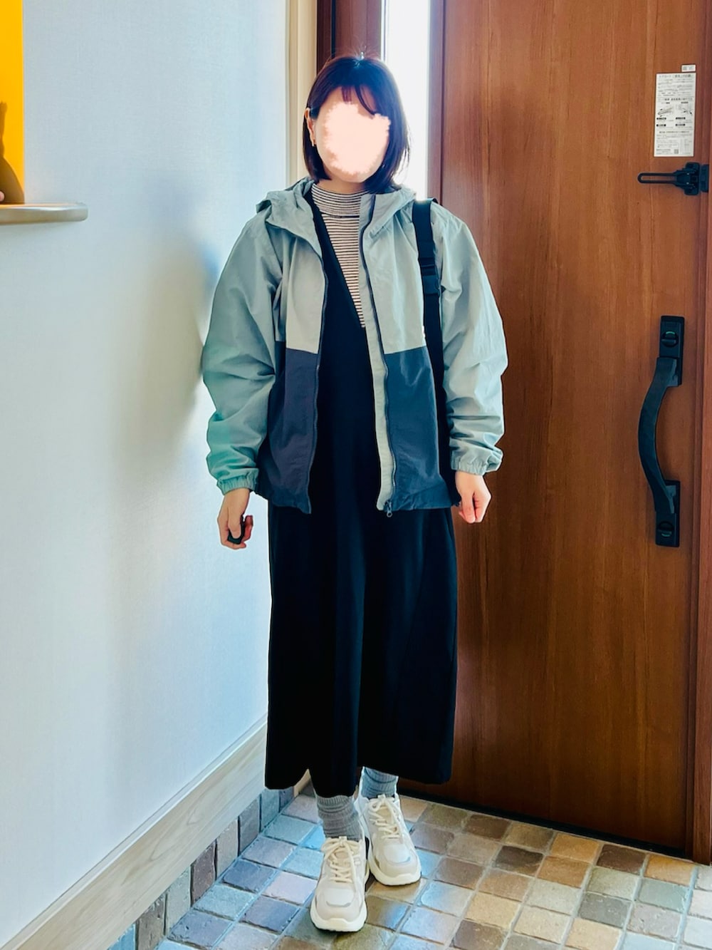 ブラック系のボディバッグ/ウエストポーチ、ブラック系のジャンパースカート、ベージュ系のスニーカーを着用したレディースの春コーディネートの2枚目の写真