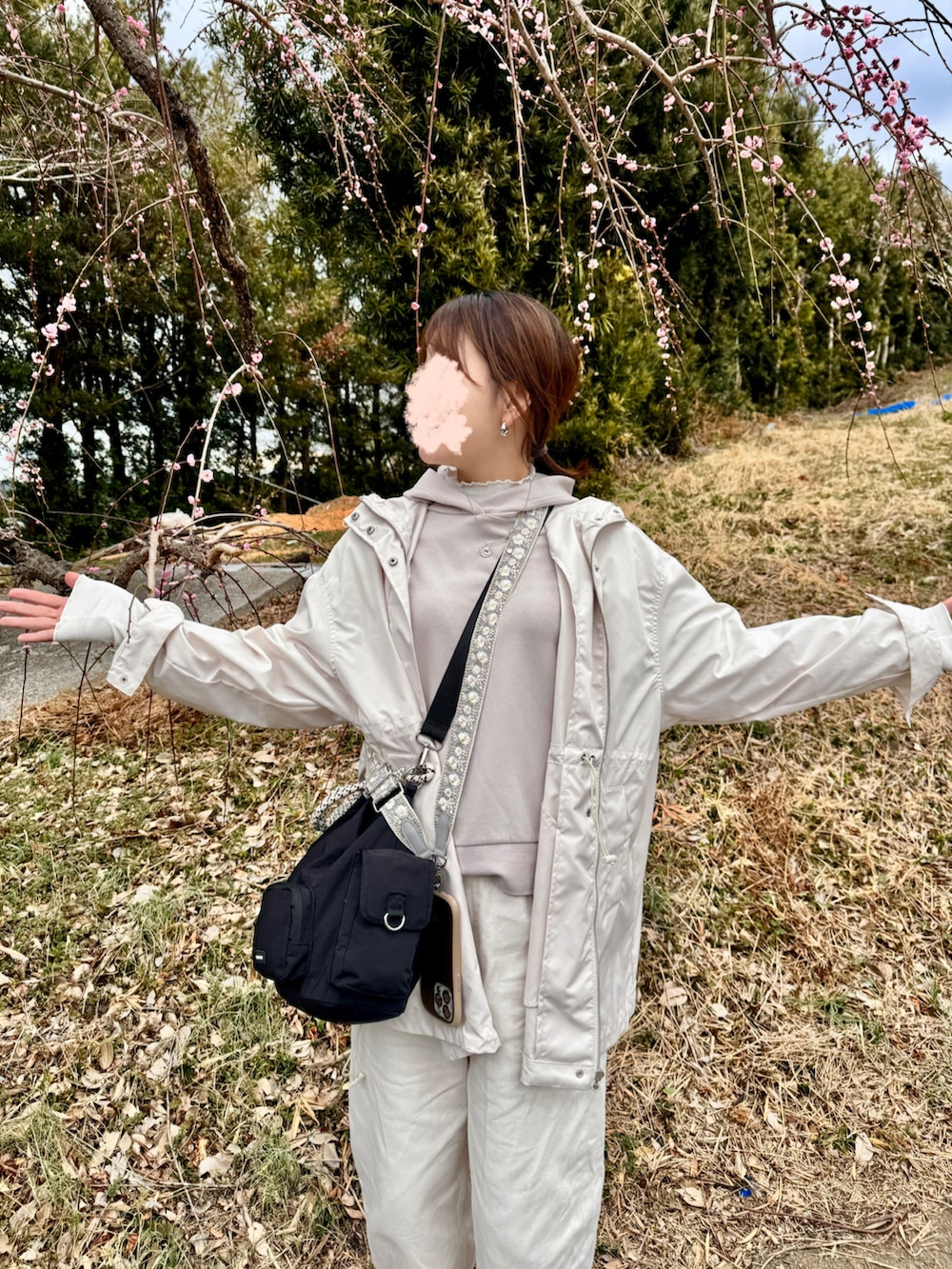 ホワイト系のデニムパンツ、ホワイト系のマウンテンパーカー、ブラック系のスリッポンを着用したレディースの冬コーディネートの3枚目の写真