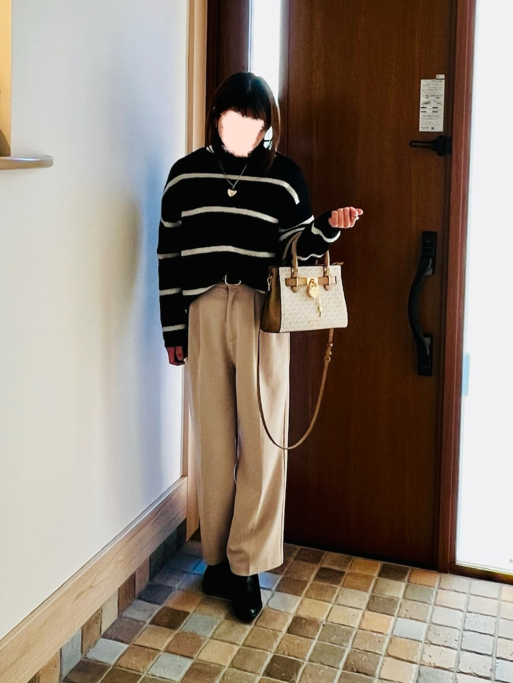 ブルー系のニット/セーター、ベージュ系のその他パンツ、ブラック系のブルゾンを着用したレディースの冬コーディネートの2枚目の写真