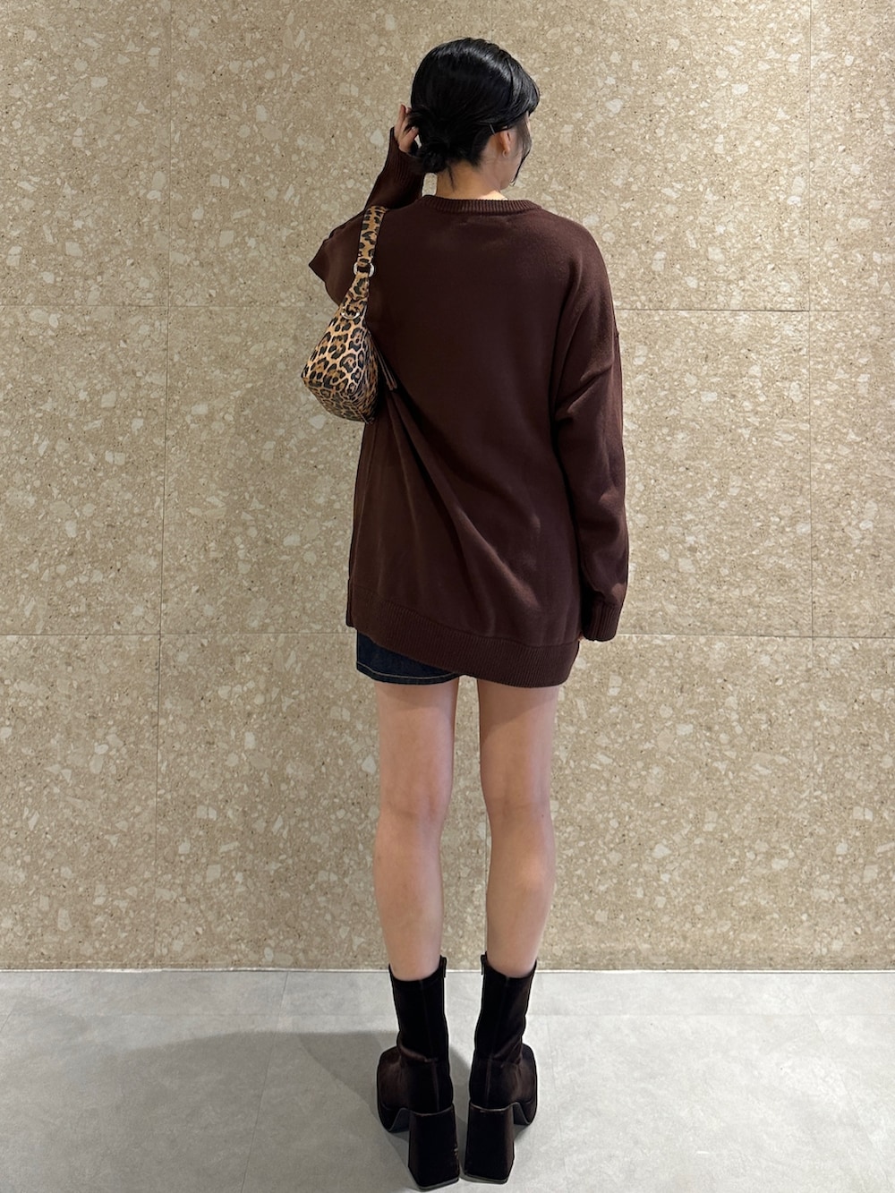 ブラウン系のニット/セーター、ブラウン系のブーツ、ブラウン系のハンドバッグを着用したレディースの秋コーディネートの3枚目の写真