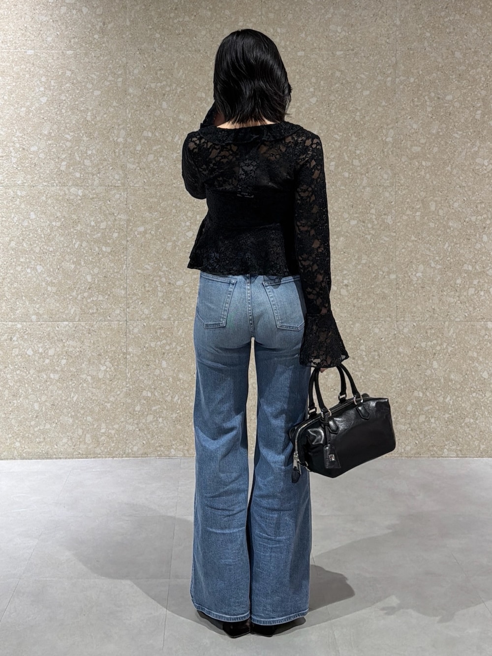 ブラック系のTシャツ/カットソー、ブルー系のデニムパンツ、ブラック系のショルダーバッグを着用したレディースの冬コーディネートの4枚目の写真