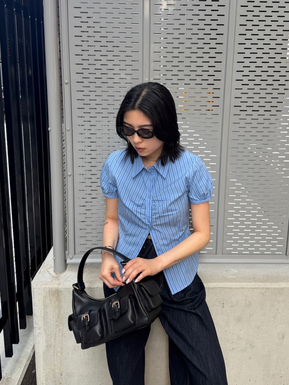 ブルー系のデニムパンツ、ブルー系のシャツ/ブラウス、ブラック系のショルダーバッグを着用したレディースの春コーディネートの4枚目の写真