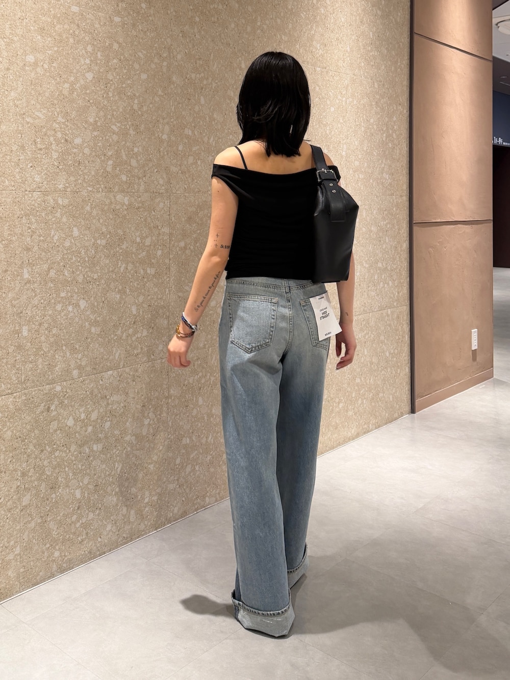ブルー系のデニムパンツ、ブラック系のブーツ、ブラック系のTシャツ/カットソーを着用したレディースの夏コーディネートの3枚目の写真