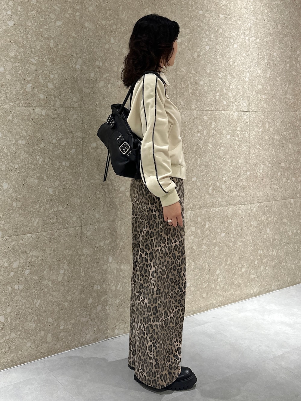 ホワイト系のジャージ、ブラウン系のデニムパンツ、ブラック系のブーツを着用したレディースの秋コーディネートの3枚目の写真