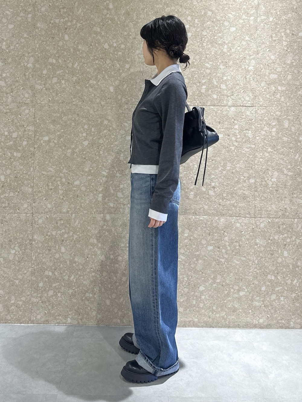 グレー系のニット/セーター、ブルー系のデニムパンツ、ブラック系のブーツを着用したレディースの秋コーディネートの3枚目の写真