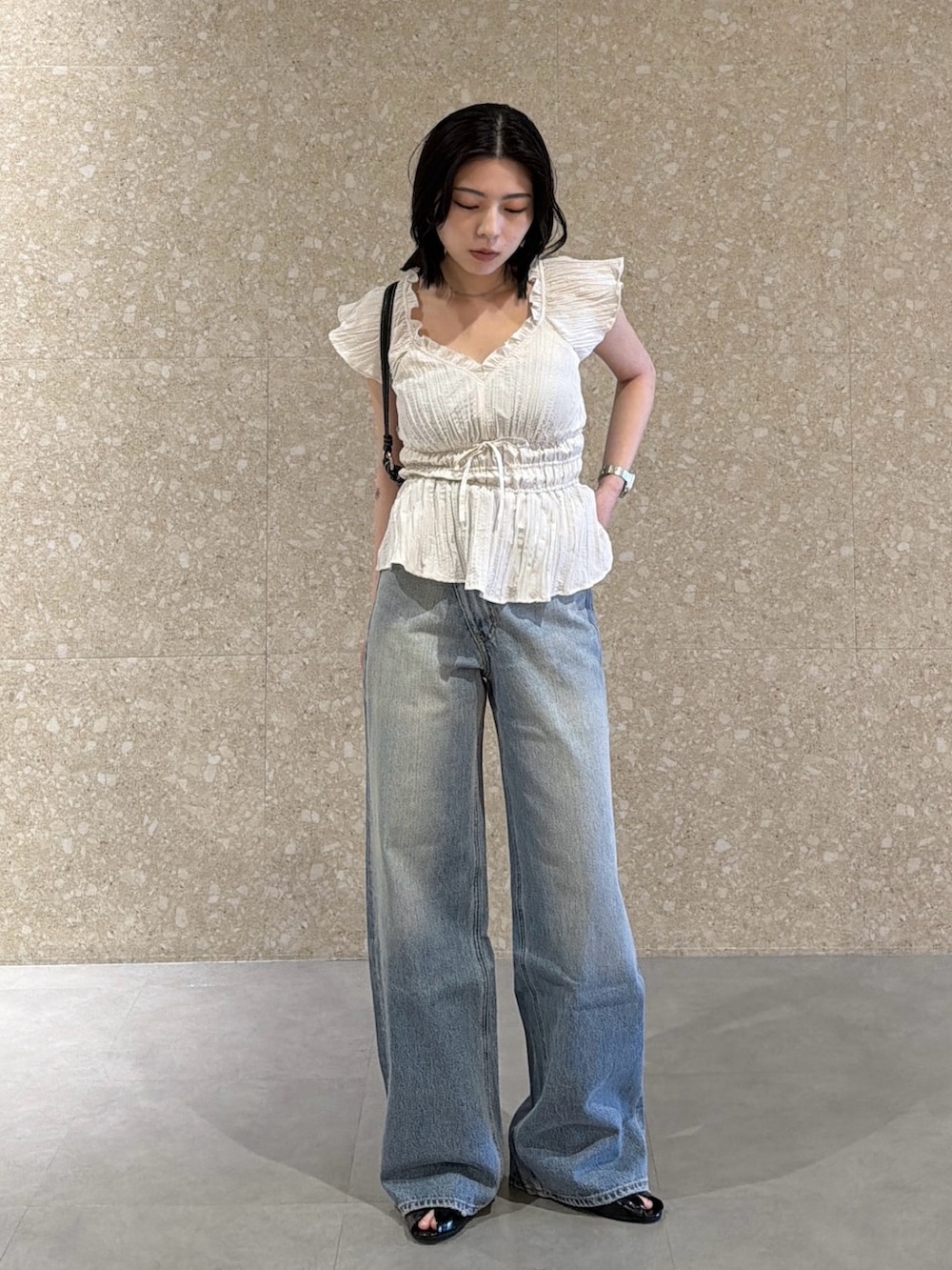 ホワイト系のシャツ/ブラウス、ブルー系のデニムパンツ、ブラック系のサンダルを着用したレディースの春コーディネートの2枚目の写真
