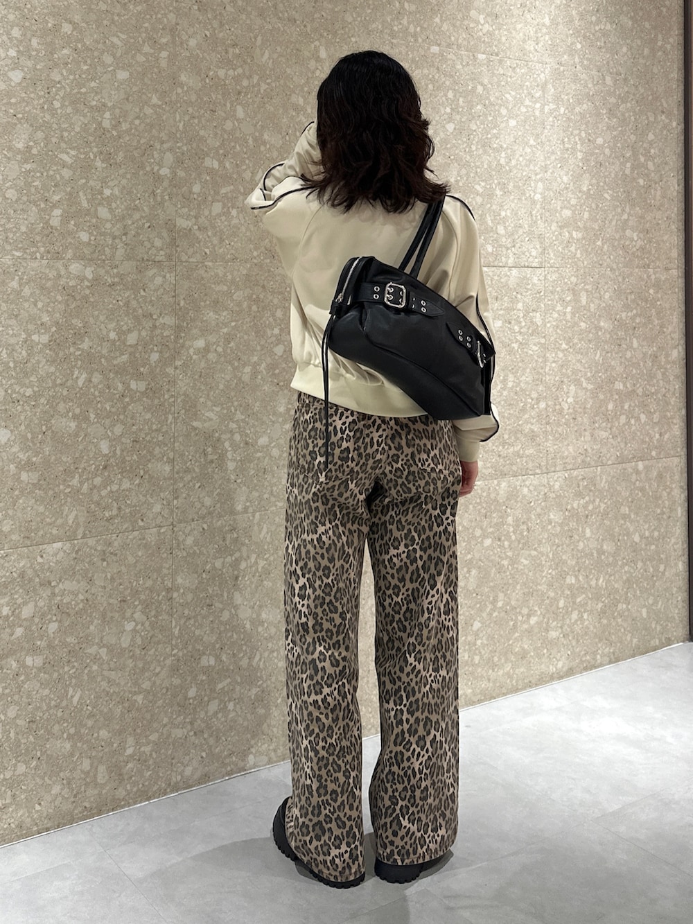 ホワイト系のジャージ、ブラウン系のデニムパンツ、ブラック系のブーツを着用したレディースの秋コーディネートの4枚目の写真