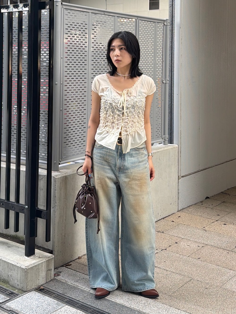 ブラウン系のブーツ、ブルー系のデニムパンツ、ホワイト系のTシャツ/カットソーを着用したレディースの夏コーディネートの2枚目の写真