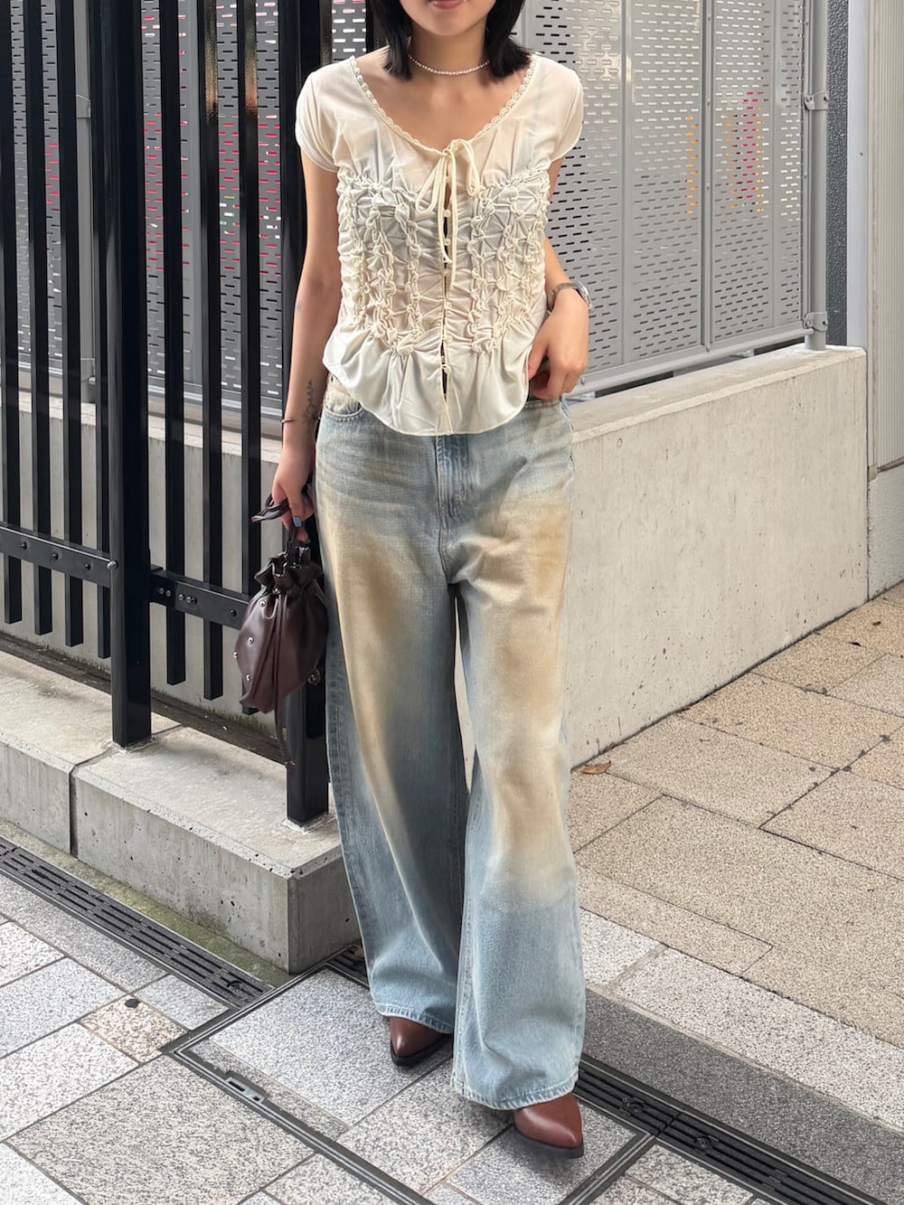 ブラウン系のブーツ、ブルー系のデニムパンツ、ホワイト系のTシャツ/カットソーを着用したレディースの夏コーディネートの5枚目の写真