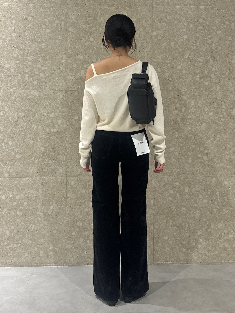 ブラック系のデニムパンツ、ブラック系のローファー、ブラック系のショルダーバッグを着用したレディースの秋コーディネートの4枚目の写真