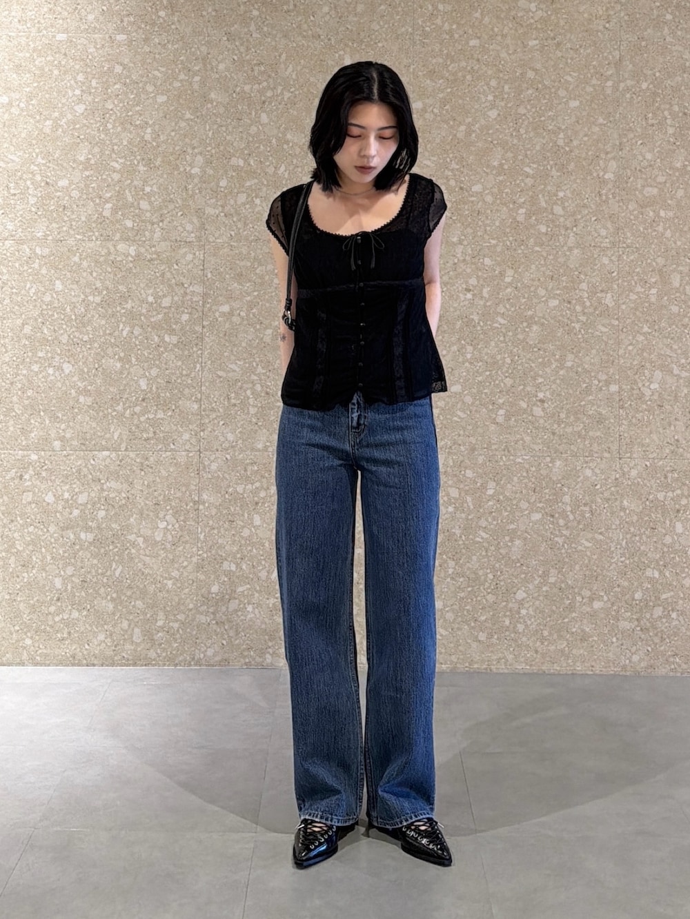 ブルー系のデニムパンツ、ブラック系のシャツ/ブラウス、ブラック系のショルダーバッグを着用したレディースの春コーディネートの3枚目の写真