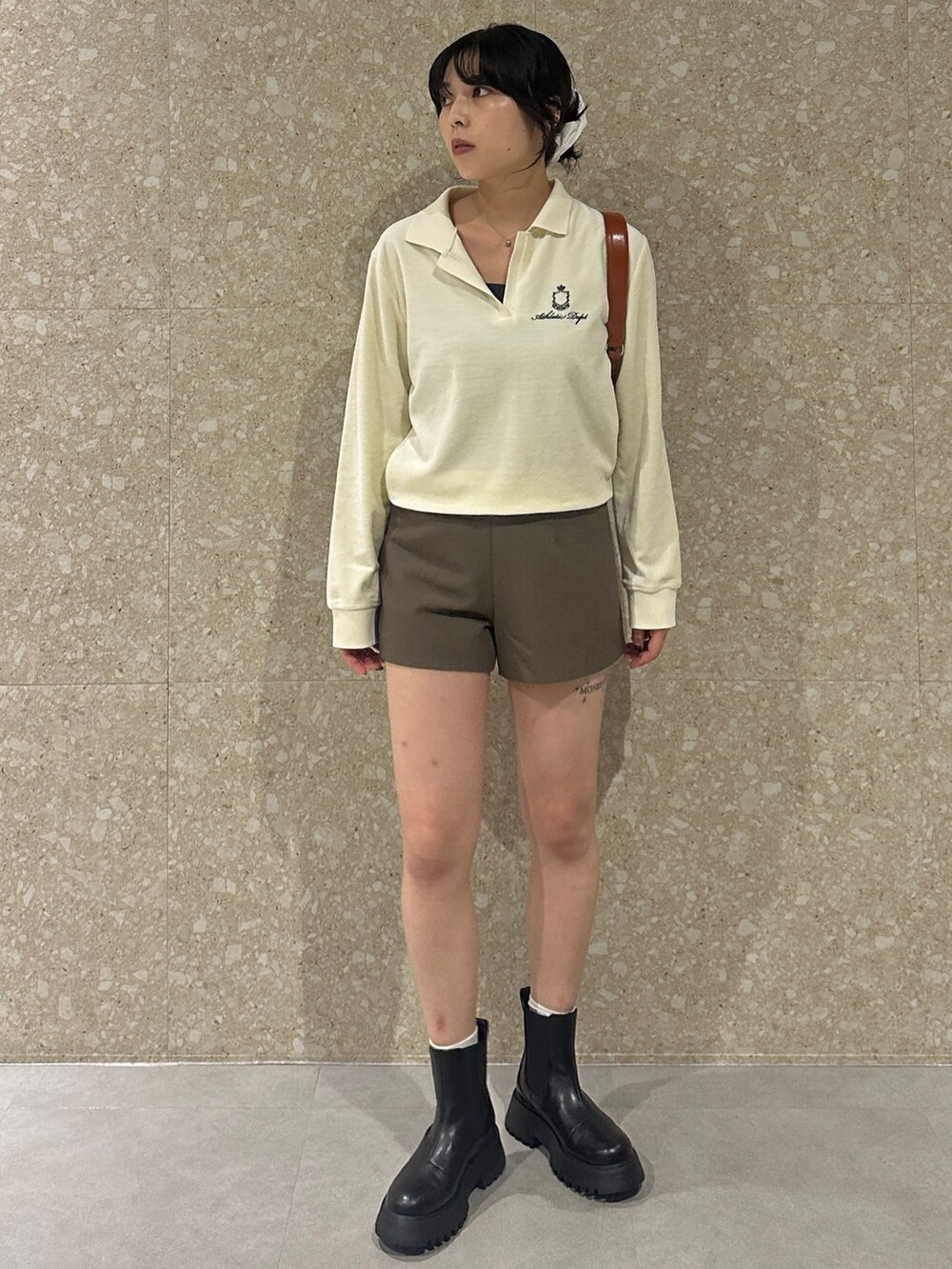 ホワイト系のTシャツ/カットソー、ブラウン系のその他パンツ、ブラック系のブーツを着用したレディースの秋コーディネートの2枚目の写真