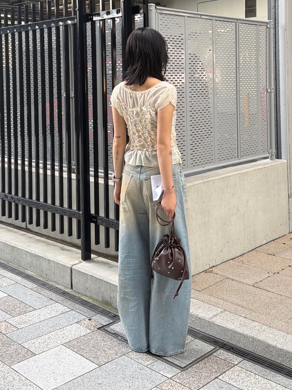 ブラウン系のブーツ、ブルー系のデニムパンツ、ホワイト系のTシャツ/カットソーを着用したレディースの夏コーディネートの3枚目の写真