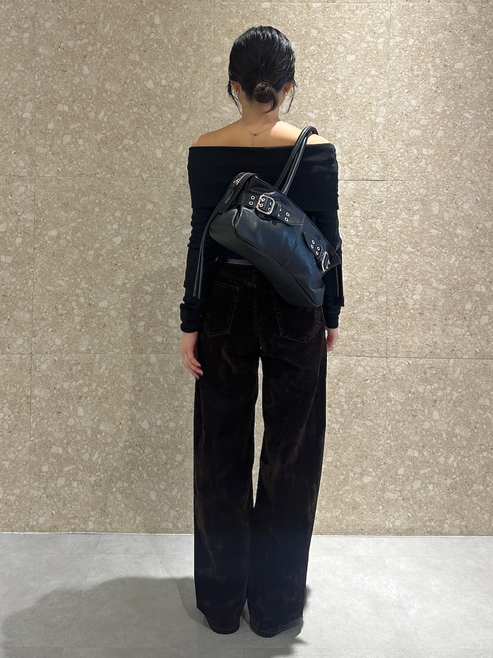 ブラック系のTシャツ/カットソー、ブラウン系のデニムパンツ、ブラック系のトートバッグを着用したレディースの秋コーディネートの3枚目の写真