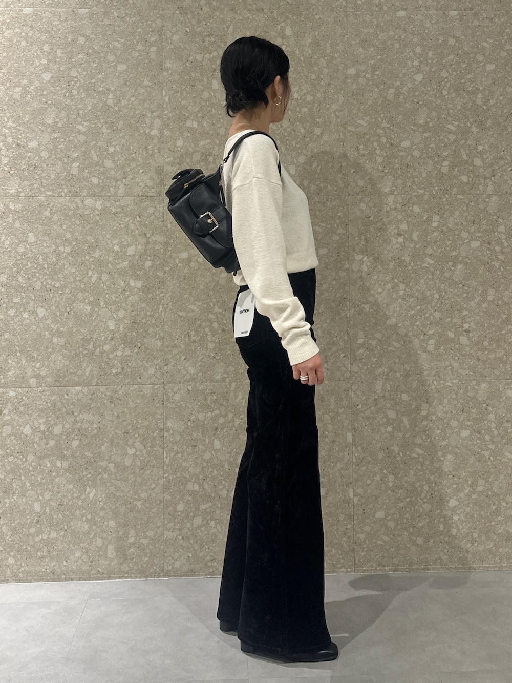 ブラック系のデニムパンツ、ブラック系のローファー、ブラック系のショルダーバッグを着用したレディースの秋コーディネートの3枚目の写真