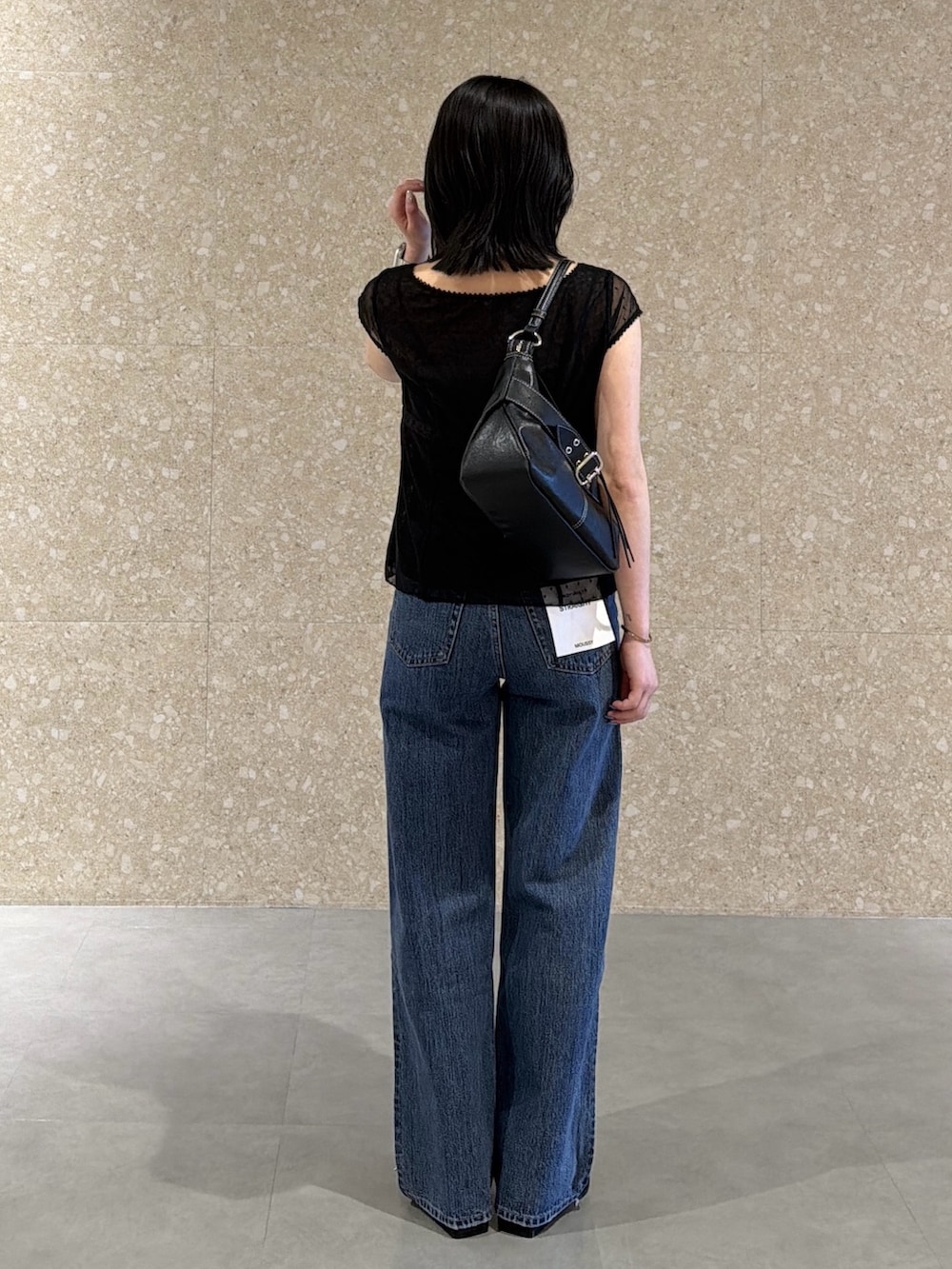 ブルー系のデニムパンツ、ブラック系のシャツ/ブラウス、ブラック系のショルダーバッグを着用したレディースの春コーディネートの4枚目の写真