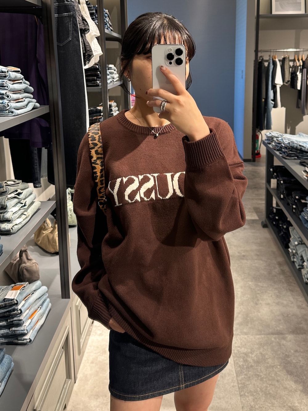 ブラウン系のニット/セーター、ブラウン系のブーツ、ブラウン系のハンドバッグを着用したレディースの秋コーディネートの5枚目の写真