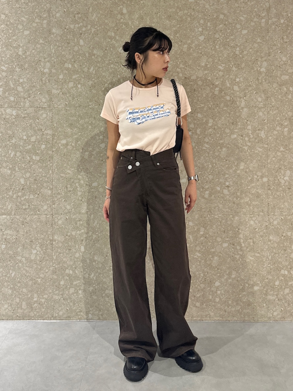 ブラウン系のチノパンツ、ブラック系のブーツ、オレンジ系のTシャツ/カットソーを着用したレディースの夏コーディネートの4枚目の写真