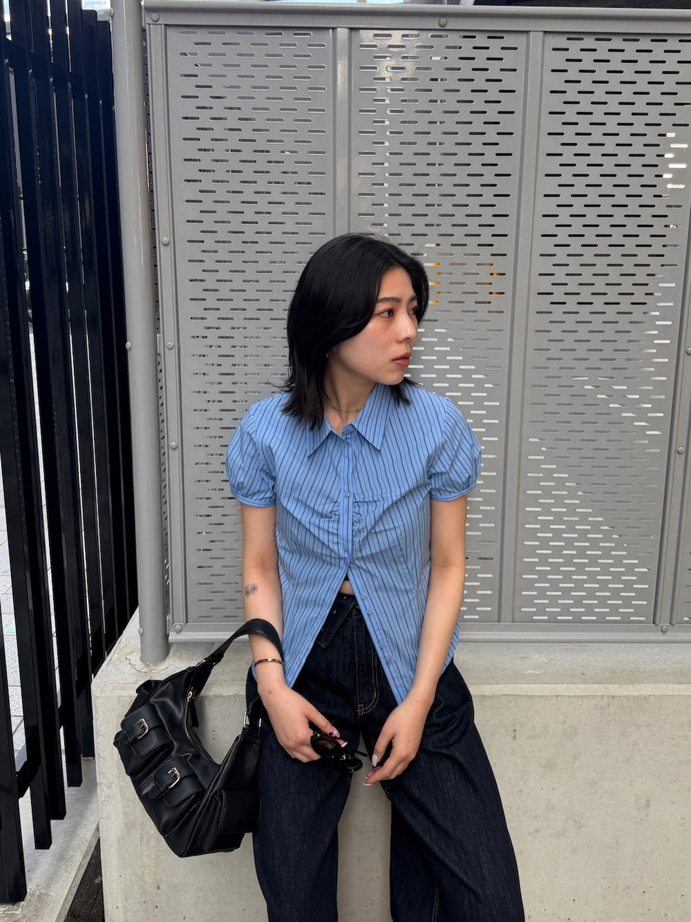 ブルー系のデニムパンツ、ブルー系のシャツ/ブラウス、ブラック系のショルダーバッグを着用したレディースの春コーディネートの3枚目の写真