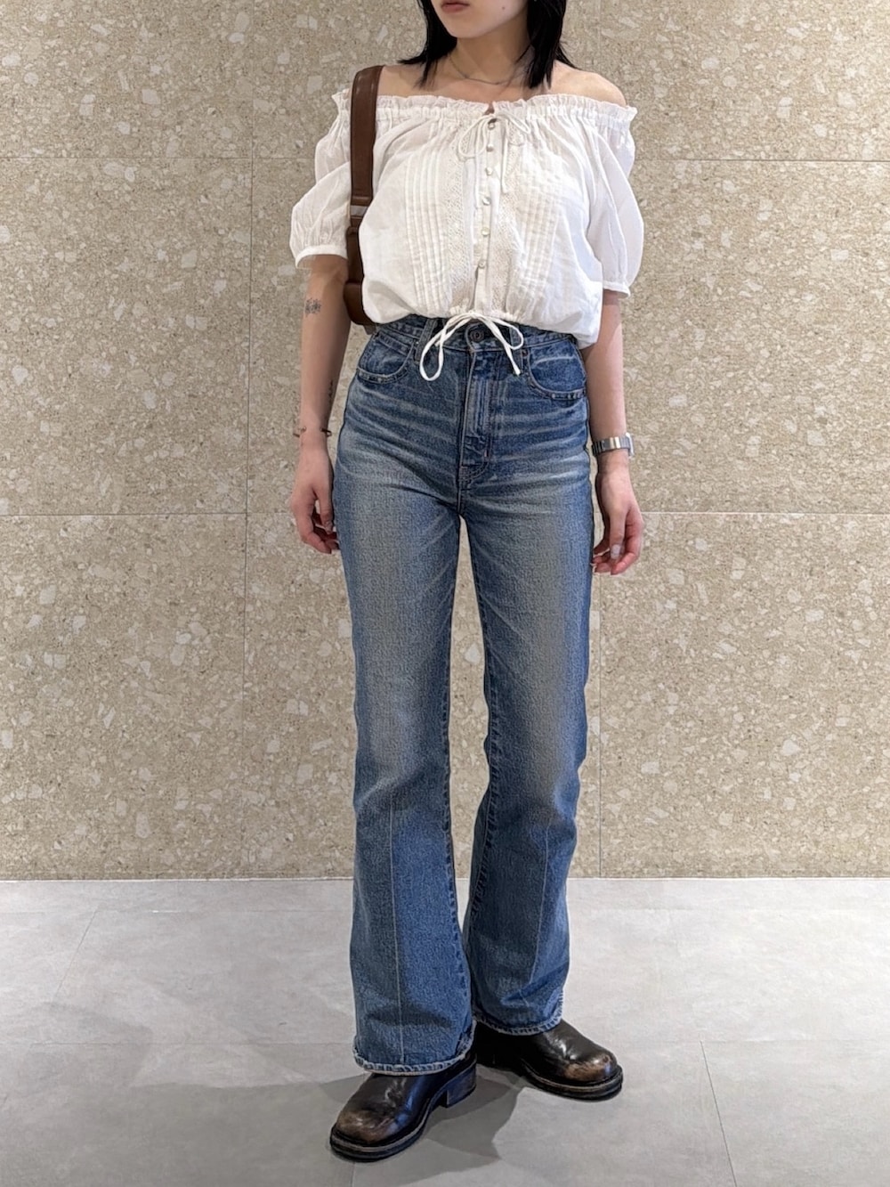ホワイト系のシャツ/ブラウス、ブルー系のデニムパンツ、ブラウン系のショルダーバッグを着用したレディースの春コーディネートの2枚目の写真